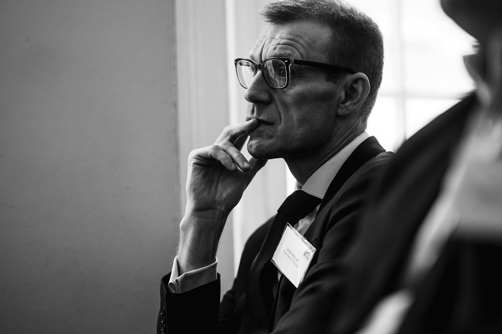 Man with glasses thoughtfully listening to meeting