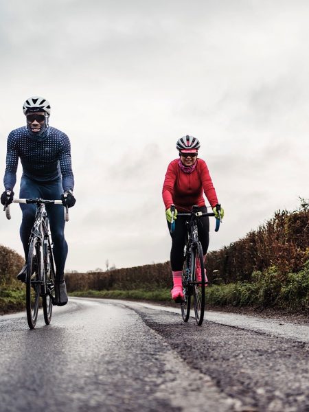Male and female cyclists on quiet country road