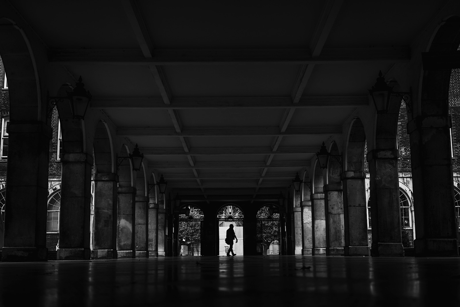 Best Locations for Street Photography in London showing image of man walking inj covered walkway