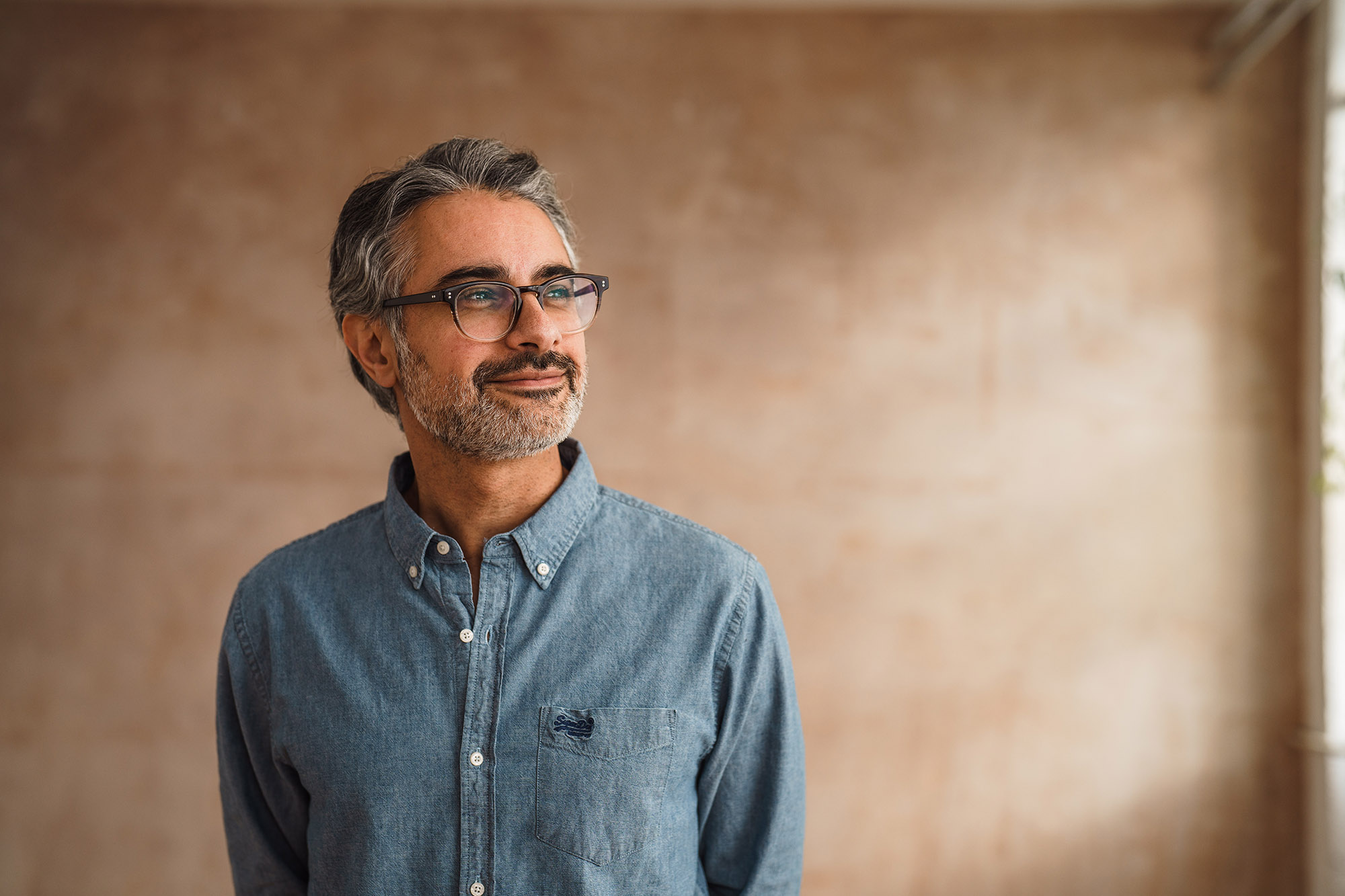 Man wearing a blue shirt and glasses smiling
