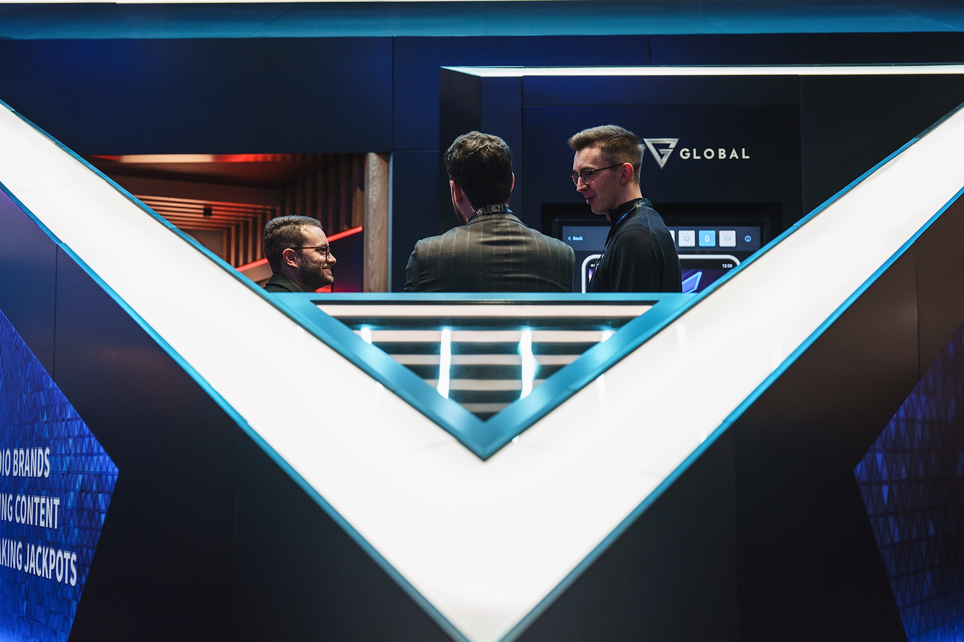 Three people stand together in a futuristic, geometric space with blue lighting and a "Global" logo in the background.